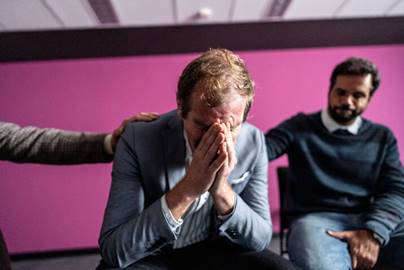 Man crying as other men care for him - Employment Law
